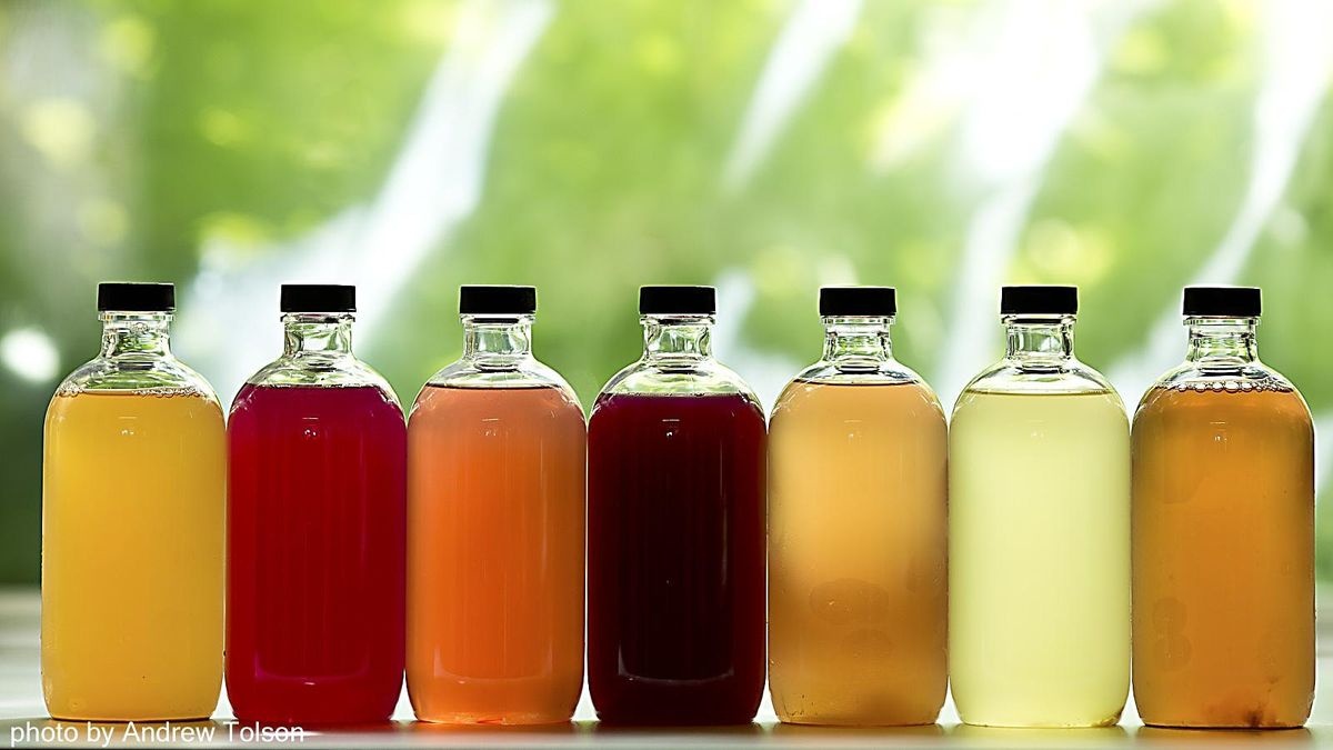 seven bottles containing different color liquids
