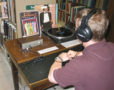 A patron listening to an LP on one of our turntables
