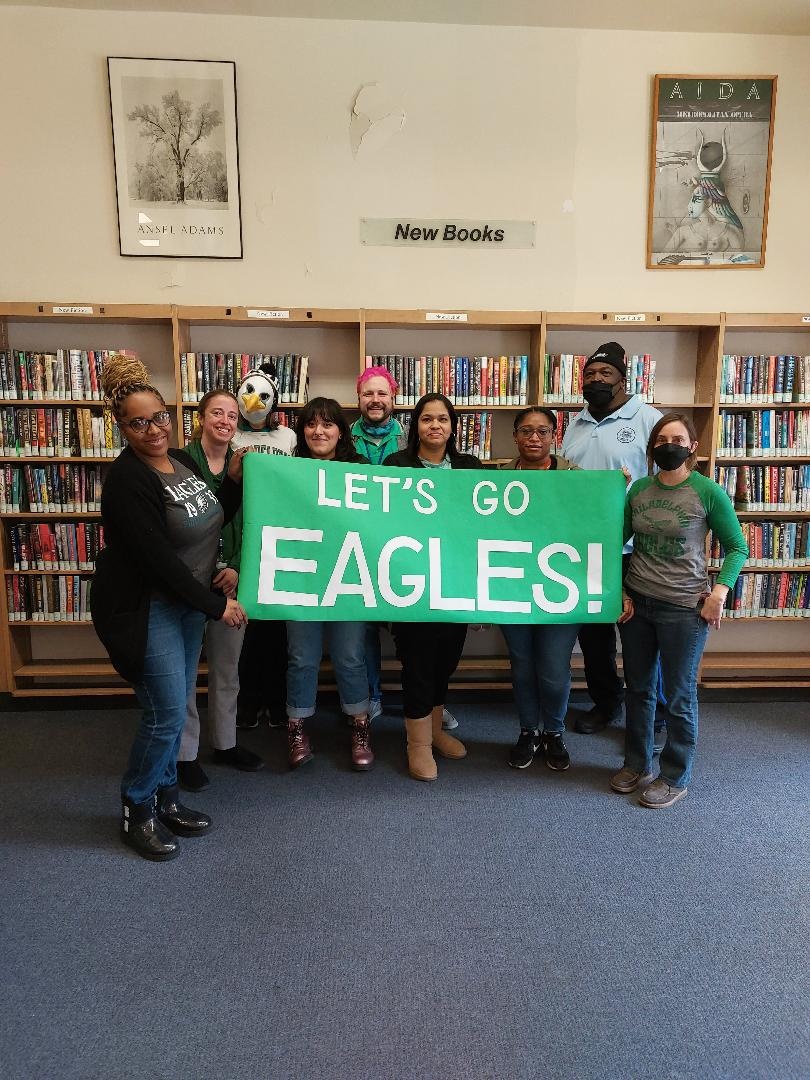 Free Library staff holding a banner that reads LET'S GO EAGLES