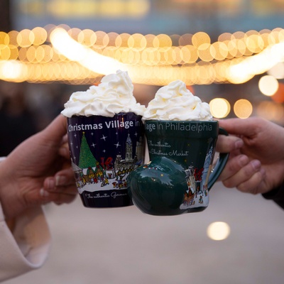Christmas Village mugs clinking with hot cocoa and whipped cream