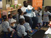 Jazz the Barber reads to some children at his business, Creative Image Unisex Salon.