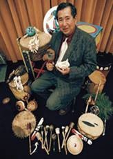Man in suit surrounded by drums