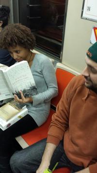 The author engrossed in some historical fiction while riding the subway.
