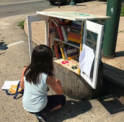 Girl in front of open sidewalk library