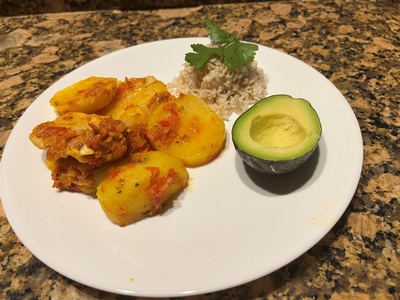 dish with sauce covered vegetables, rice, and avocado