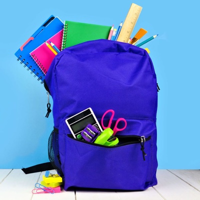 Stock image of purple backpack overflowing with school supplies 